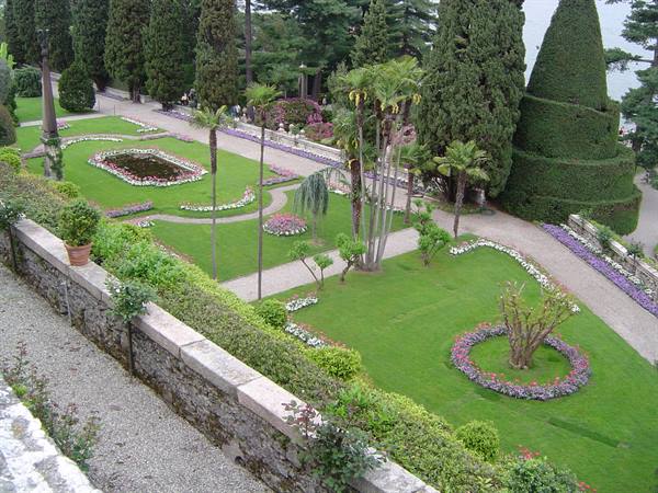 Terraced gardens of Isola Bella with flowerbeds, palms and cypresses overlooking Lake Maggiore