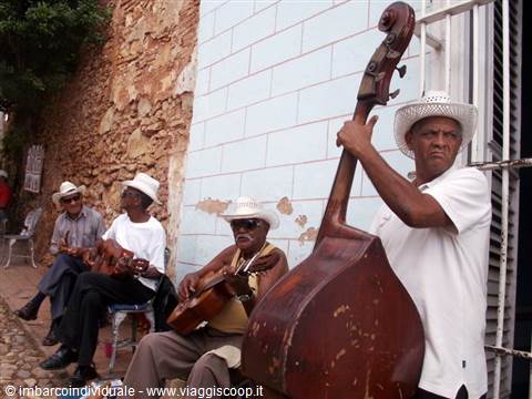 Musicians playing guitars and double bass on a street in Trinidad, Cuba