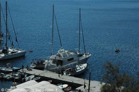 Sailboats and yachts moored at the harbor pier of Poros