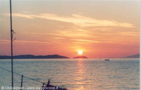 Low sun over the sea with small islands, boat rigging in foreground