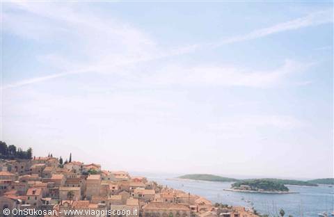 Red rooftops of Hvar town overlooking blue harbor and green islands