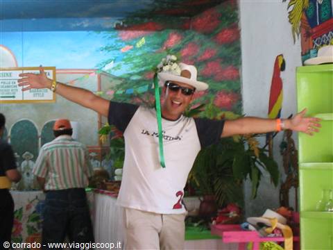 Man in white hat spreading his arms inside a colorfully painted room