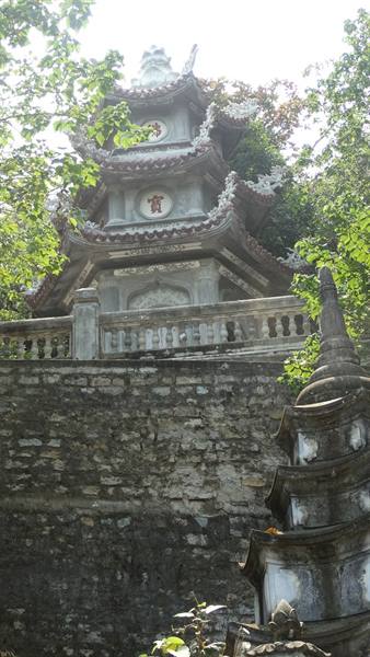 Stone Buddhist pagoda among trees, carved balustrade and weathered stupa