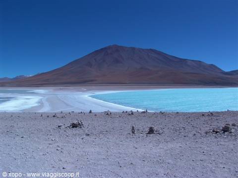 Laguna Verde: turquoise water, white shore and volcano under blue sky