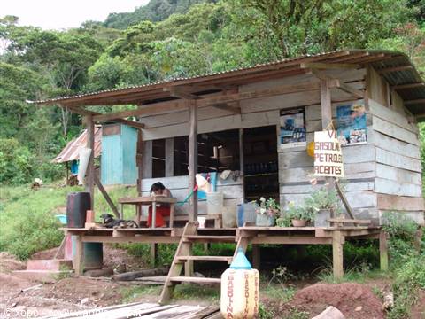 Woman sitting under the wooden porch of a small timber store