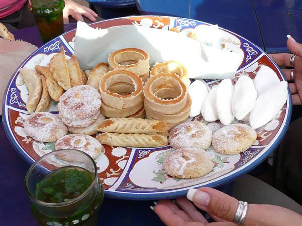 Decorated plate of sugary pastries and fried sweets served with mint tea