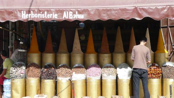 Vendor fills spice cones at the Herboristerie Al Bahja shop