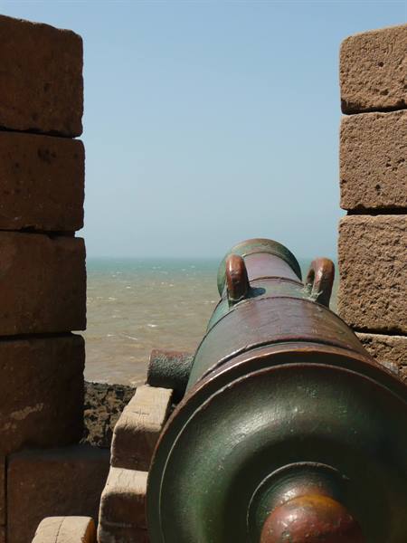 Green-bronze cannon on Essaouira fortress walls, pointing toward the ocean