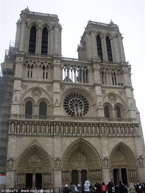 Gothic facade of Notre-Dame in Paris with rose window and twin towers, tourists below