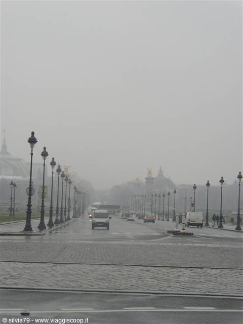 Paris, Pont Alexandre III in the fog, cars and lampposts on wet cobblestones