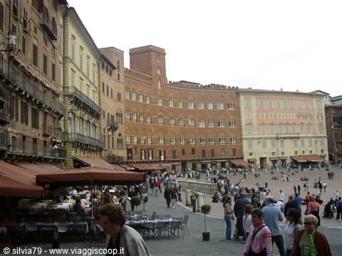 Tourists and café umbrellas in Siena's Piazza del Campo