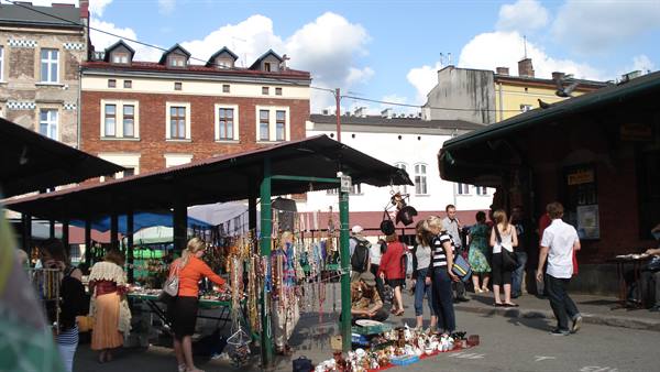 Shoppers and vendors among souvenir stalls at the open-air market in Kazimierz, Krakow