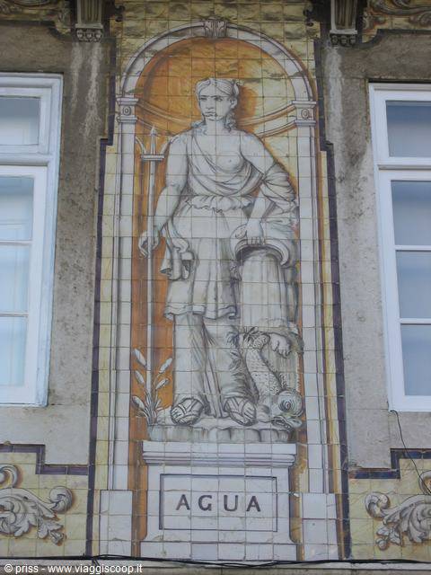 Pannello di azulejos con figura femminile e scritta "Água" su facciata lisbonese