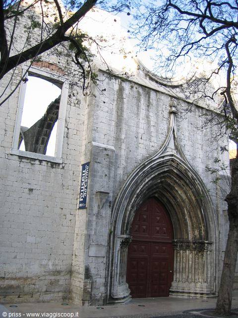 Portale gotico del Carmo tra rami spogli e luce pomeridiana a Lisbona