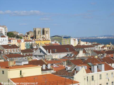 Lisbon rooftops with the Sé Cathedral under a blue sky