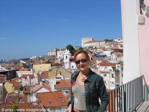 Girl with sunglasses on a terrace, behind Lisbon rooftops and the castle
