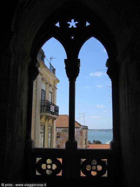 Gothic stone window overlooking the Tagus River and Lisbon buildings