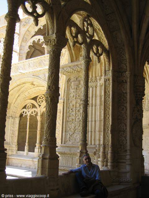 Jerónimos Monastery cloister: carved stone columns, man sitting on the bench
