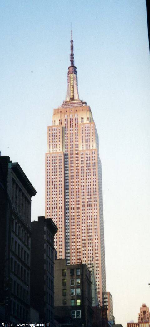 The limestone Empire State Building rises among skyscrapers at dusk