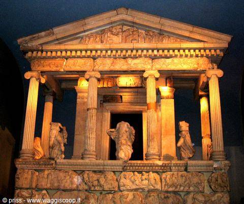 Nereid Monument, stone tomb temple with columns and statues, lit indoors