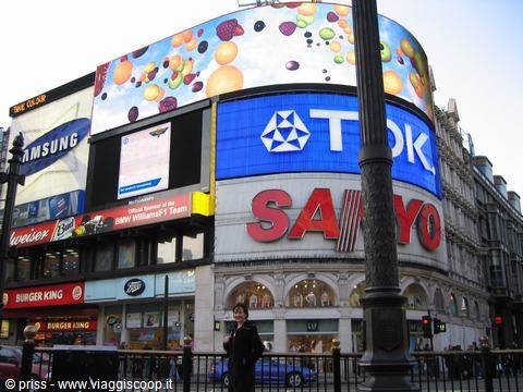 Woman by the lamppost beneath the illuminated billboardsof Piccadilly Circus, London