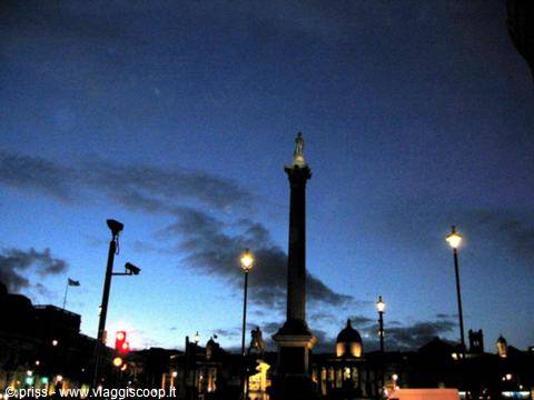 Nelson's Column at Trafalgar Square, London, lit against the blue evening sky