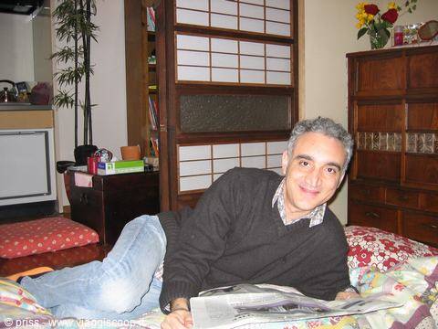 Sdraiato con il giornale sul futon, stanza tradizionale con shoji in legno