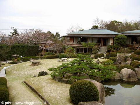 Giardino con pini e rocce davanti a casa tradizionale in legno, Kurashiki