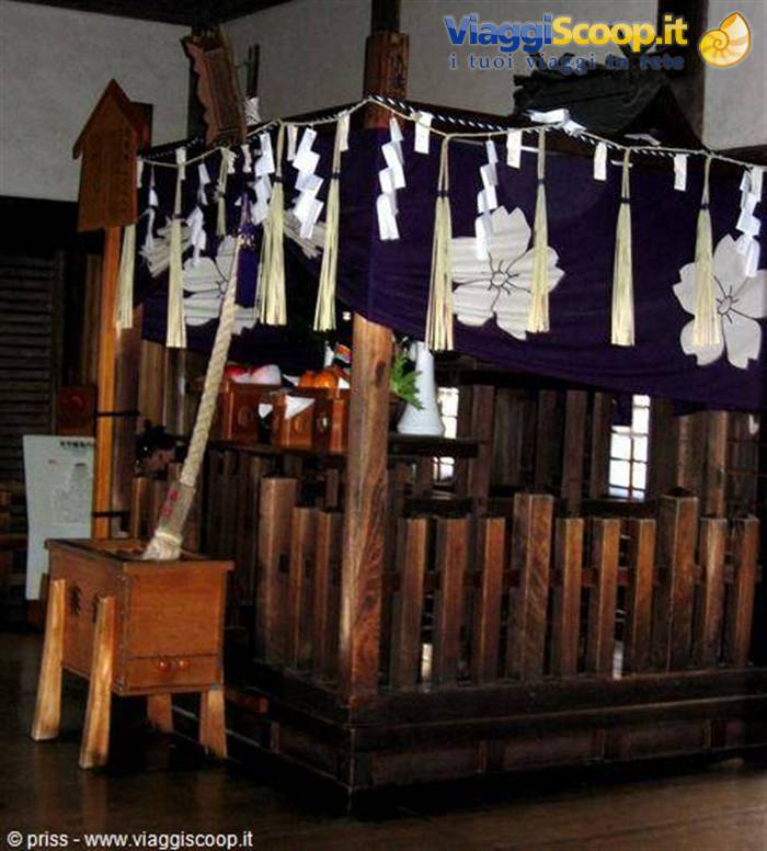 Altare in legno con corde shimenawa e bandiere viola, santuario interno