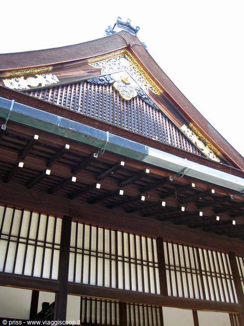 Wooden Japanese temple roof with dark beams and golden ornaments