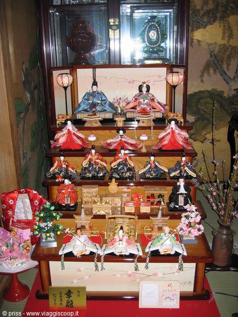 Hina ningyo doll display on lacquered wooden tiers with lit lanterns