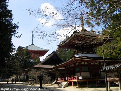 Koyasan, padiglioni rossi in legno e pagoda tra cipressi sotto nuvole bianche