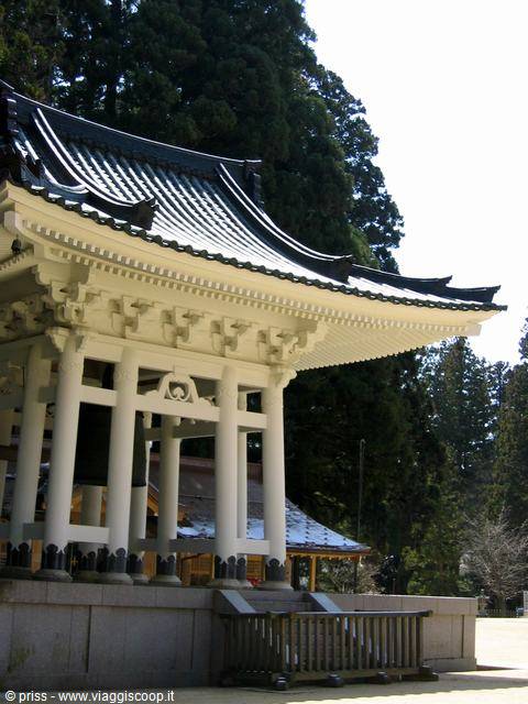 Tetto bianco e campana del tempio sotto i cedri di Koyasan