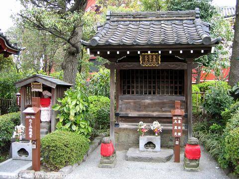 Small wooden shrine with tiled roof, flowers and offerings, Senso-ji Tokyo