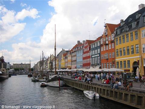 Nyhavn in Copenhagen: colorful townhouses by the canal, boats and crowds on the quay