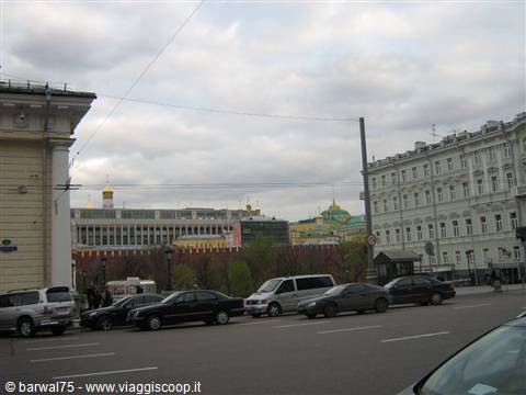 Cars parked near the Moscow Kremlin, golden domes under cloudy sky
