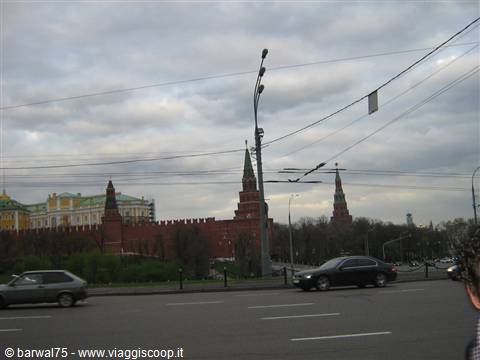 Red walls and towers of the Moscow Kremlin seen from city traffic