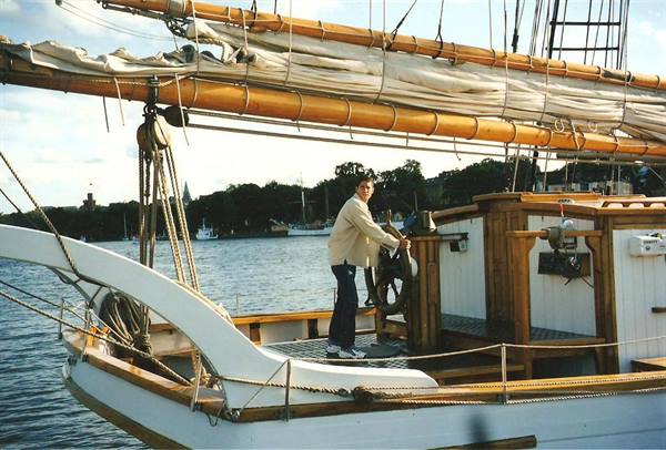 Boy at the helm of a wooden schooner in Stockholm harbor