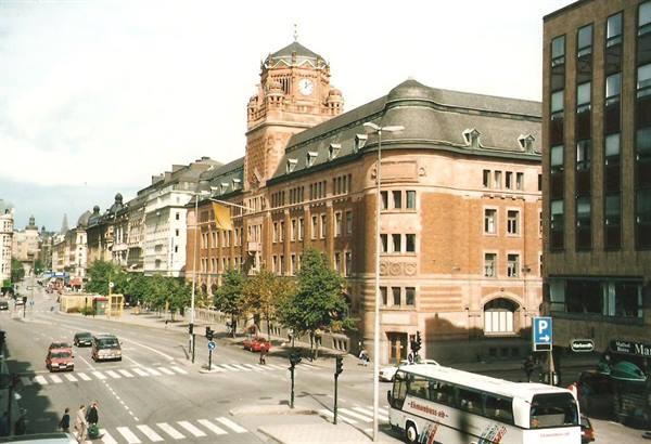 Stockholm's red-brick Central Post Office with clock tower, bus crossing below