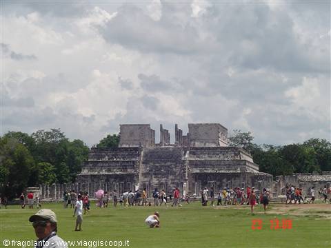 Tourists on the lawn in front of the Temple of the Warriors at Chichén Itzá, cloudy sky
