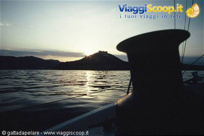 Sailboat winch silhouetted against island castle on the horizon