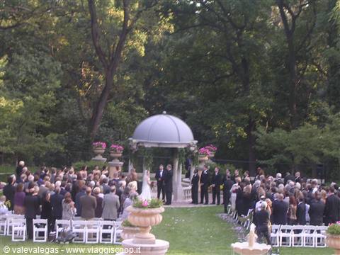 Wedding ceremony under a domed gazebo in a leafy green park