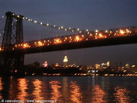 Williamsburg Bridge lit up at night over the East River, New York