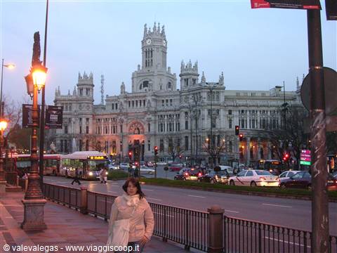 Cibeles Palace in Madrid lit at dusk, traffic and a lit street lamp in foreground