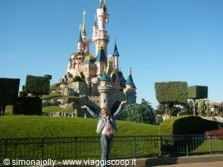 Woman with raised arms in front of the Sleeping Beauty Castle, Disneyland Paris
