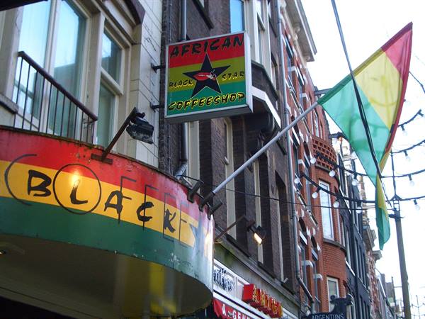 African Star coffee shop sign and red-green-yellow flag on brick facade