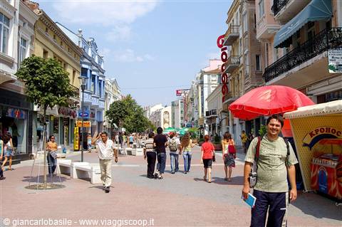 Tourists walk along the pedestrian street, red umbrella and food kiosk