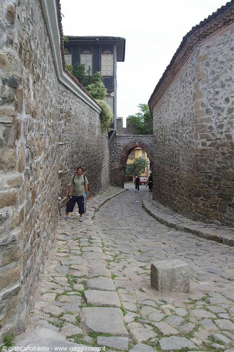 Tourist beside the historic Hisar Kapia gate among stone walls in Plovdiv