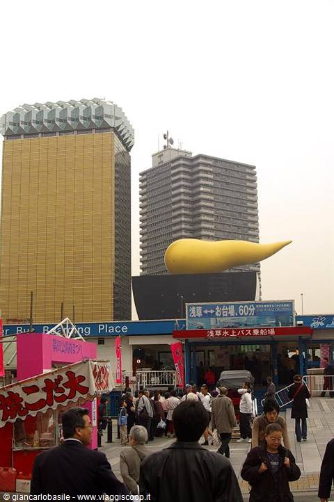 Asahi golden flame building in Asakusa, Tokyo, crowd below grey sky
