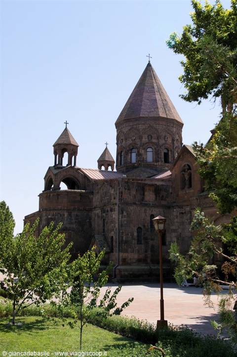 Etchmiadzin Cathedral, stone conical dome among green trees